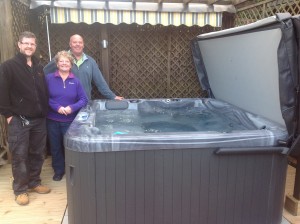 Jamie handing over a new spa to Mr & Mrs Spooner